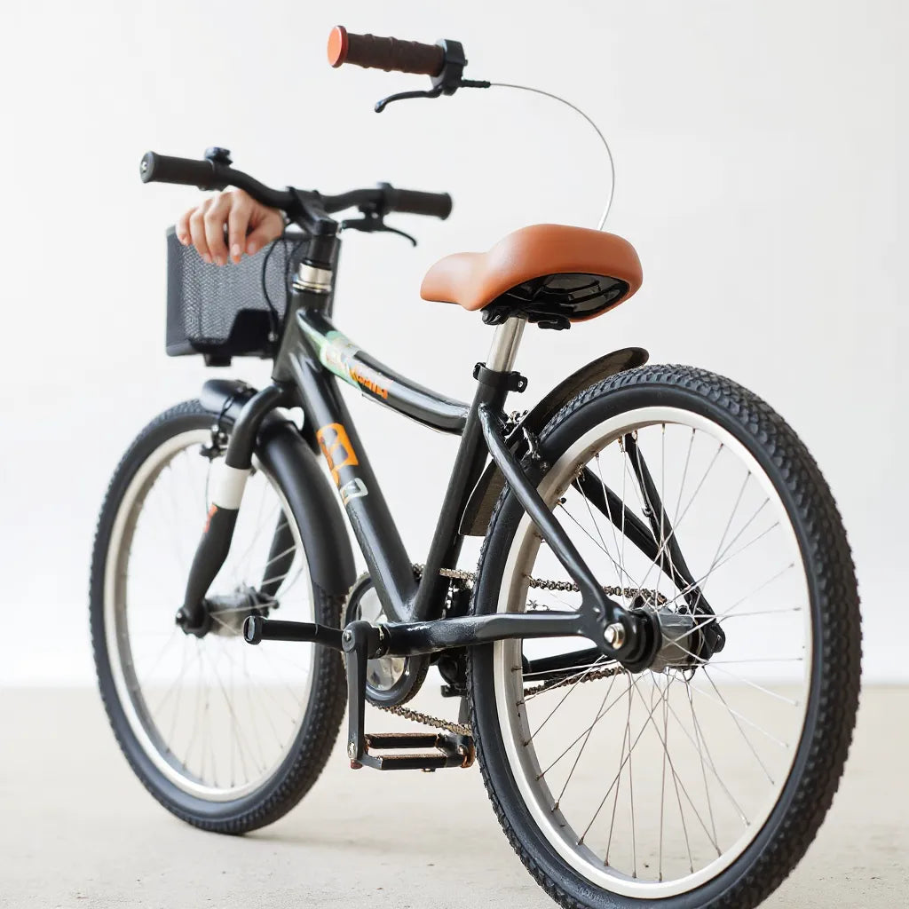 Kinderfahrrad mit sichtbaren Bremsen, Lichtern, Schutzblechen und Reflektoren, während ein Elternteil prüft